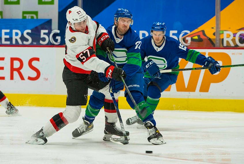 Vancouver Canucks forward Travis Boyd battles Ottawa Senators forward Shane Pinto in the first period at Rogers Arena.
