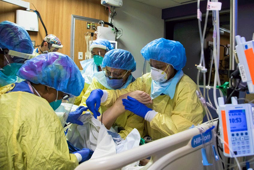 A respiratory therapist and six nurses with a COVID-19 patient inside the intensive care unit of Humber River Hospital in Toronto, April 19, 2021.
