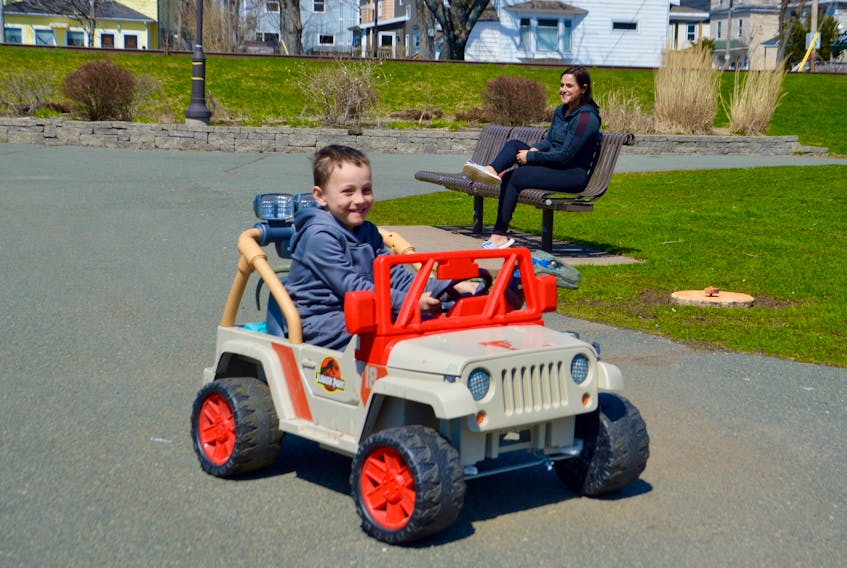Silas MacDonald is all smiles as he navigates his Jurassic Park jeep through the wilds of Wentworth Park in Sydney. The four-year-old Shipyard neighbourhood resident knew he was safe with mom Suzanne DeFlavio sitting on a nearby park bench and his own personal dinosaur Blue the Raptor riding shotgun. DAVID JALA/CAPE BRETON POST