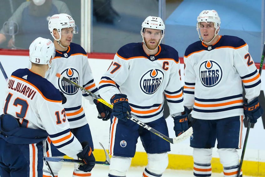 Edmonton Oilers centre Connor McDavid (second from right) sort of celebrates his third goal of the game against the Winnipeg Jets on Monday.