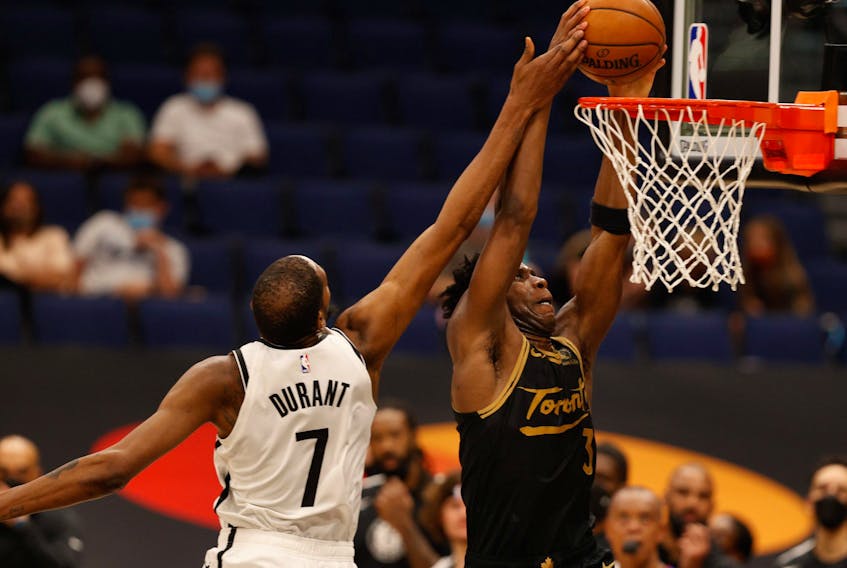 Toronto Raptors forward OG Anunoby dunks over Brooklyn Nets forward Kevin Durant on Tuesday.