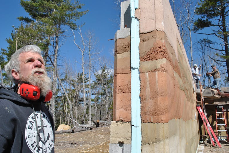 Tom Torak stands beside one of the rammed earth exterior walls for the home he is building in Hartz Point in Birchtown, just outside Shelburne. KATHY JOHNSON - Saltwire network