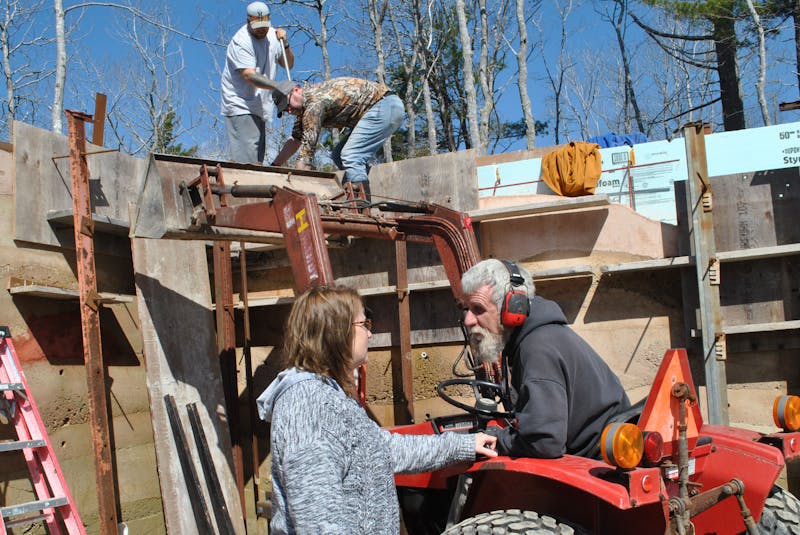 Laura and Tom Torak talk for a minute at the site of their rammed earth house build in Hartz Point. In the background packing the rammed earth into the exterior walls are  Christian Hammond (right) and Alex MacKenzie. KATHY JOHNSON - Saltwire network