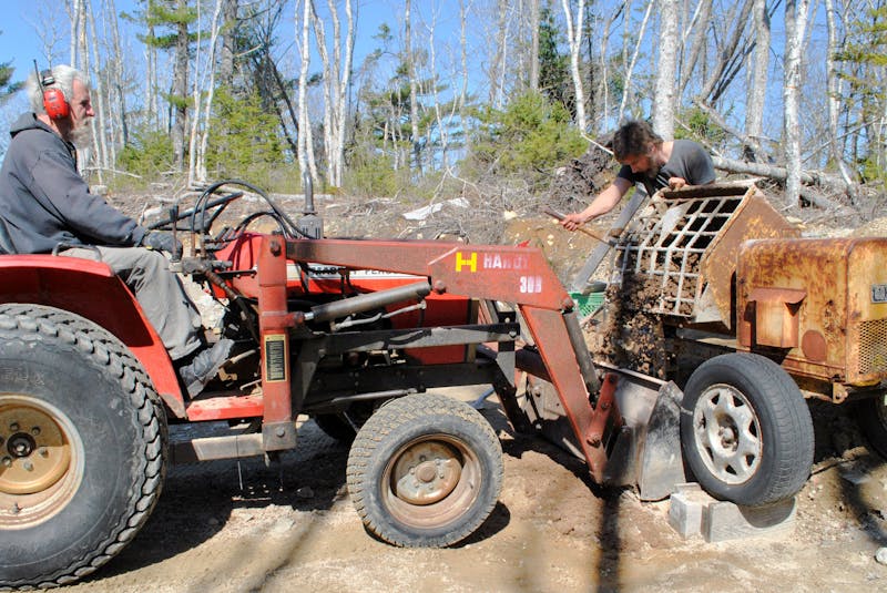 Brennen Labrador  pours a load of rammed earth into the bucket of a front-end loader being driven by Tom Torak at the build site in Hartz Point in Birchtown.  KATHY JOHNSON

 - Saltwire network
