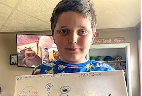 Kyrin Matthews, 7, of Sydney Mines, holds up a picture he drew to promote the importance of following public health directives. Matthews, who was a close contact with someone who was an active COVID-19 case at Shipyard Elementary School, is now self-isolating at home and said everyone has to stay home now as if not they might get COVID-19 and took to art to remind people of the important steps.