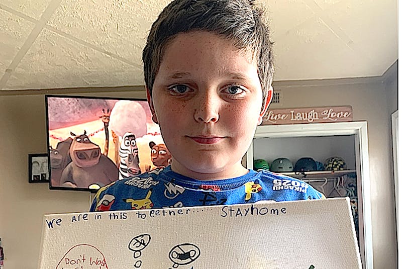 Kyrin Matthews, 7, of Sydney Mines, holds up a picture he drew to promote the importance of following public health directives. Matthews, who was a close contact with someone who was an active COVID-19 case at Shipyard Elementary School, is now self-isolating at home and said everyone has to stay home now as if not they might get COVID-19 and took to art to remind people of the important steps. - CONTRIBUTED