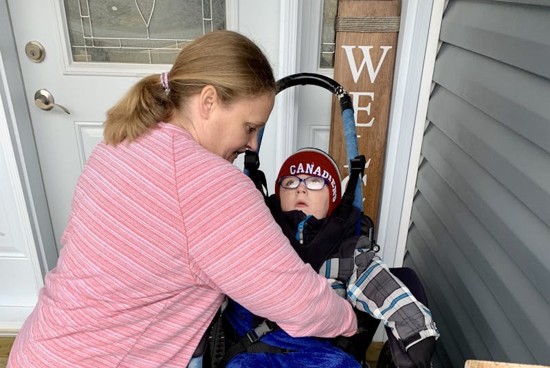 Adina Stamp gets her five-year-old son, Lyndon, situated in a specialized wheelchair in front of their Bay Bulls home before heading out for a hike earlier this week. The specialized wheelchair was borrowed from the Janeway children's hospital, but Stamp hopes the family can someday have one of their own. - Rosie Mullaley