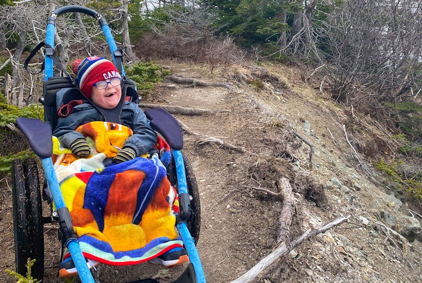 Five-year-old Lyndon Andersen was all smiles earlier this month during a hike with his brother, Zander, and their mother, Adina Stamp, at LaManche trail. The specialized Hippocampe wheelchair the family borrowed from the Janeway children's hospital enables Lyndon to enjoy places with all kinds of surfaces and rough terrain. 