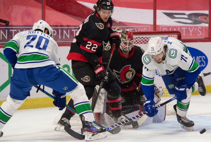  Vancouver Canucks forward Zack MacEwen (right) goes for the puck in the first period against the Ottawa Senators.