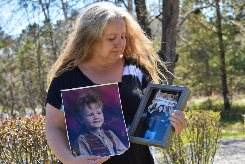 Lori Phillips gets emotional while remembering how excited her late son, Aaron Cogswell, was to find the chair he’s carrying in one of the photos she’s holding. Cogswell was thrilled to find the chair for his sister, who was moving into a new place. – Ashley Thompson