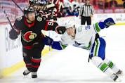 Vancouver Canucks' Nils Hoglander, right, and Ottawa Senators' Victor Mete battle for the puck during first period NHL action in Ottawa on Wednesday, April 28, 2021.
