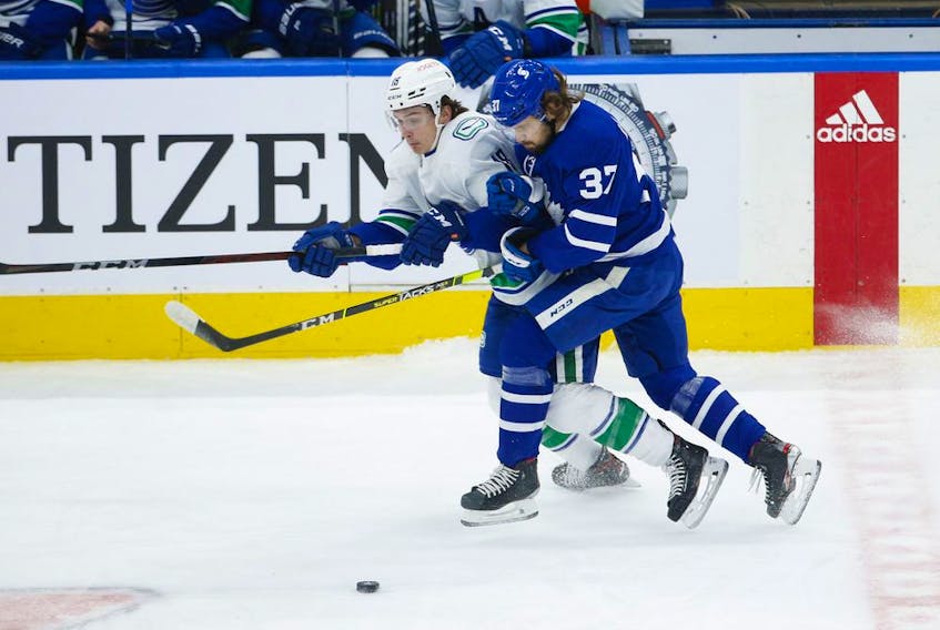 Toronto Maple Leafs Timothy Liljegren D (37) collides with Vancouver Canucks Jake Virtanen LW (18) during the first period in Toronto on Thursday April 29, 2021. Jack Boland/Toronto Sun/Postmedia Network