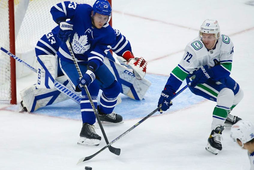 Toronto Maple Leafs Travis Dermott D (23) keeps the puck away from Vancouver Canucks Travis Boyd C (72) during the second period in Toronto on Thursday April 29, 2021. Jack Boland/Toronto Sun/Postmedia Network