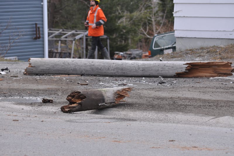 Part of the light pole that was cracked off after it was hit by a minivan early Friday morning, April 30, 2021, on Country Road in Corner Brook lies on the ground at the scene. The minivan then crashed into the Country Flowers building.  - Diane Crocker