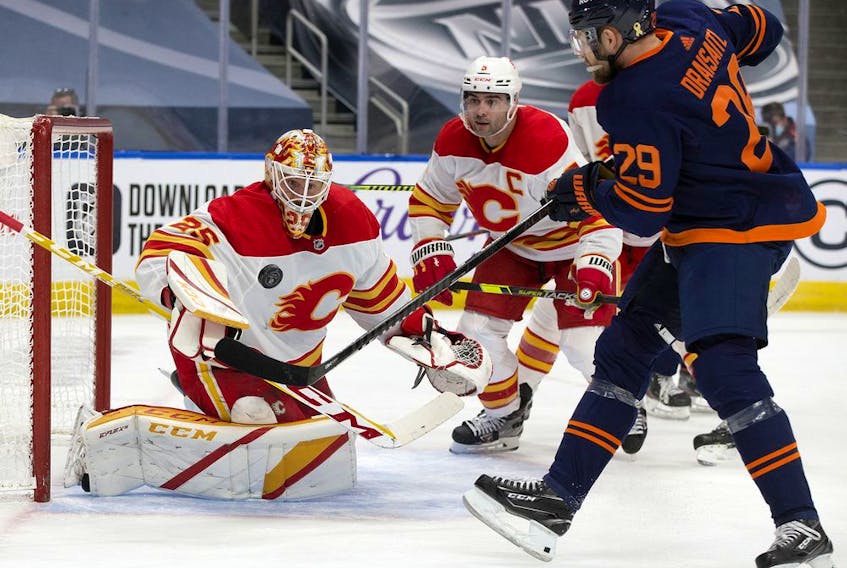  Oilers forward Jesse Puljujarvi battles Sean Monahan during third-period NHL action at Rogers Place in Edmonton on Thursday, April 29, 2021. The Flames won 3-1.