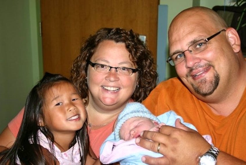 Sylvia Berrey and her late husband, Wallace, are pictured with their daughter, Lily, and son, Will, shortly after Will's birth. Berrey's sister carried Will through a surrogate pregnancy.