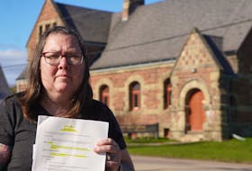 Tammy Riley, a Georgetown resident, holds the town's parking bylaw outside the Kings County Courthouse on April 29.