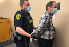 A sheriff’s officer escorts Edwin James Smith from the courtroom during a recess at provincial court in St. John’s Wednesday morning. 