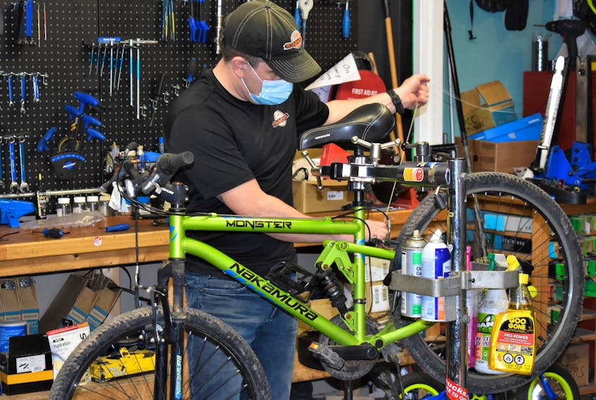 Pictou County Cycle owner Clint Snell working on a bike. The service part of his business has been busy and the retail part as well, but it has been impacted greatly by a lack of product.