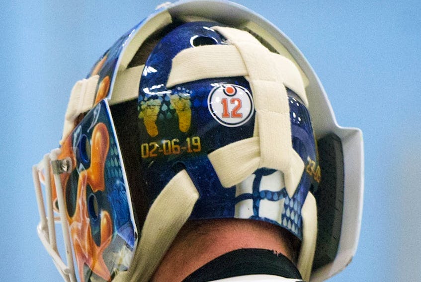 A No. 12 sticker is visible on Edmonton Oilers goaltender Mikko Koskinen's helmet in honour of the late Colby Cave during a training-camp scrimmage, in Edmonton on July 22, 2020.