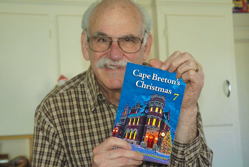 Ronald Caplan holds his seventh installation of his Cape Breton Christmas book series.