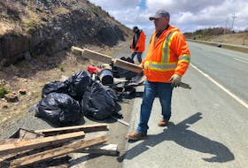 Among the Transportation and Infrastructure employees cleaning up the Outer Ring Road on Sunday were Harold Cobb and Derek George, pictured near the Team Gushue  Highway exit piling garbage for pickup. Joe Gibbons • The Telegram