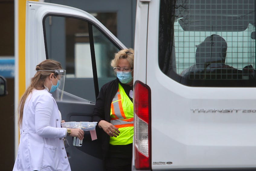Nurses prepare a patient for their vaccine, as they sit in their vehicle at the drive-thru vaccination site near Dartmouth General Hospital Monday May 10, 2021. The patient's vehicle was too tall to fit in the drive-thru garage so the nurses took the vaccine to his vehicle.

TIM KROCHAK PHOTO