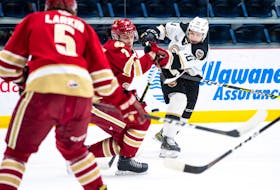 Charlottetown Islanders captain Brett Budgell, right, fires a shot towards the Acadie-Bathurst Titan goal during Game 3 of the Quebec Major Junior Hockey League's Maritimes Division final Tuesday in Shawinigan, Que.