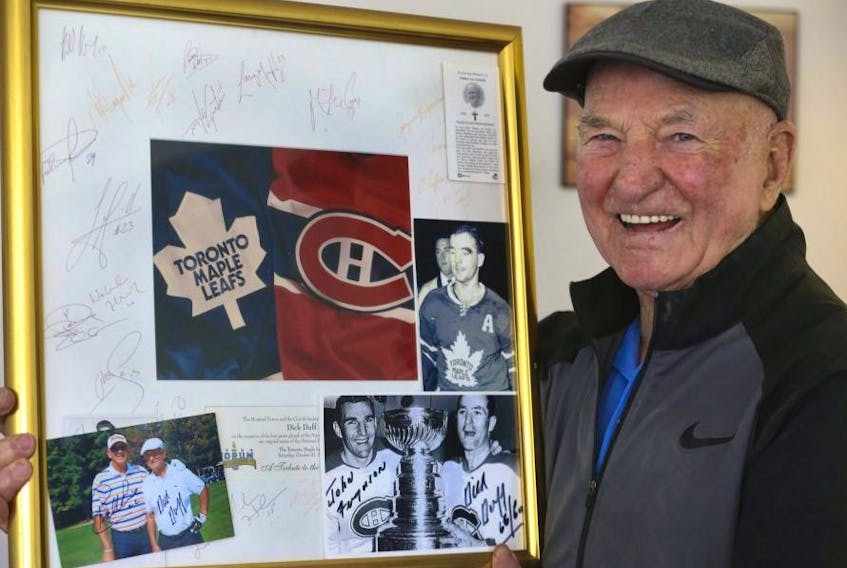 NHL legend Dick Duff holds up a framed Habs-Leafs memento signed by the two teams after they their last game at the Montreal Forum. Duff won six Stanley Cups between the two teams. JACK BOLAND/TORONTO SUN