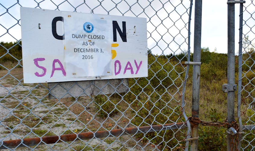A paper sign announcing the Town of Shelburne dump was closed as of Dec. 3, 2016 is stapled over a wooden sign on the gate that says the site is open on Saturdays  in this 2018 photo. The paper sign recently met its demise due to do wear and tear from the weather, causing concern for the Shelburne based South End Environmental Injustice Society (SEED) that people may think the site was actually operational. In an email to the group, Mayor Harold Locke assured them it would be replaced. KATHY JOHNSON