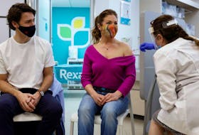 Canada's Prime Minister Justin Trudeau watches as his wife Sophie Gregoire is inoculated with AstraZeneca's vaccine in Ottawa  on April 23, 2021.