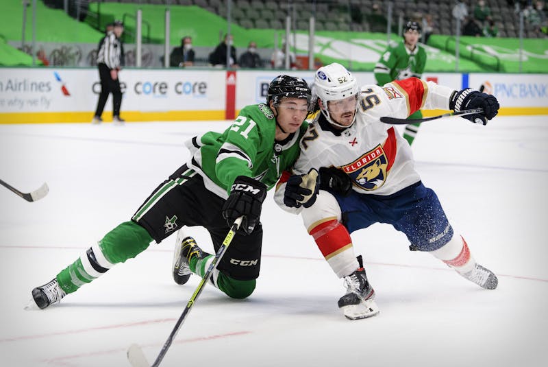 Florida Panthers defenceman MacKenzie Weegar (52) and Dallas Stars winger Jason Robertson (21) fight for the puck during an April 13 NHL game at the American Airlines Center in Dallas. - Jerome  Miron