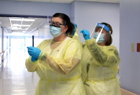 At Cape Breton Regional Hospital in Sydney, infection prevention and control practitioners Karrie Dunn, RN, left, and Lynn Boutilier, RN, demonstrate the types of personal protective equipment worn by staff and physicians who provide care to patients with COVID-19 which includes gowns, gloves, masks and face shields. Half the number of patients treated in the Cape Breton Regional Hospital COVID unit overall since the beginning of the pandemic, was over the past two weeks. Lynn Gilbert/Nova Scotia Health