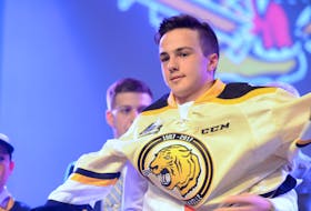 Charlottetown Islanders winger Cedric Desruisseaux pulls on the Victoriaville Tigres jersey after being drafted by them in the first round of the 2016 Quebec Major Junior Hockey League draft at the Eastlink Centre.