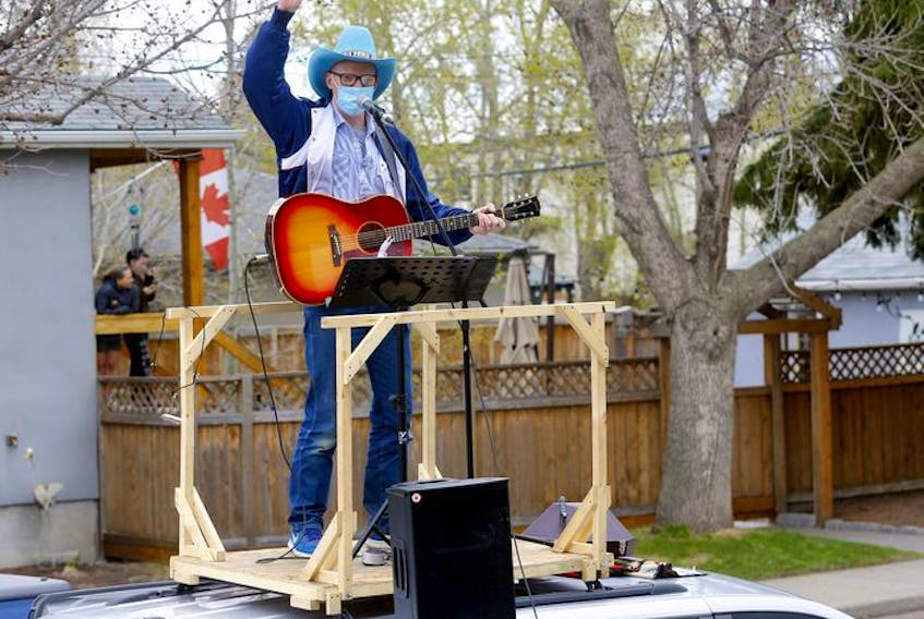 Matt Masters, founder of Curbside Concerts performs on top of his van during a Birthday Party in Calgary on Saturday, May 9, 2020. Darren Makowichuk/Postmedia