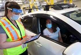 May 19, 2021--Registered Nurse Sarah Woycik goes over health information prior to administering a dose of Pfizer vaccine to drive-thru patient Deidre Taylor at the clinic behind Dartmouth General Wednesday.
ERIC WYNNE/Chronicle Herald