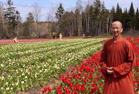 Venerable Dan Huang, one of the monks at the Great Enlightenment Buddhist Institute Society, stands in the group's field in Heatherdale.