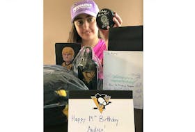 Audrey McCarthy displays the gifts and autographed cards sent to her by Sidney Crosby and the Pittsburgh Penguins.