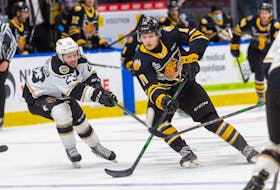Charlottetown Islanders centre Zac Beauregard, left, tries to lift the stick of Victoriaville Tigres centre Maxime Pellerin Sunday during Game 4 of the Quebec Major Junior Hockey League semifinal in Quebec City. - Jonathan Roy