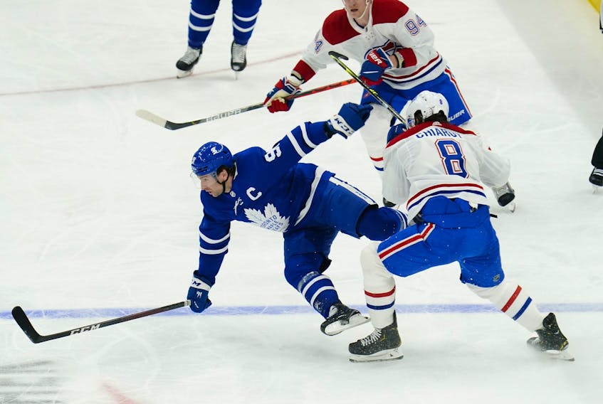 Toronto Maple Leafs forward John Tavares (91) is hit by Montreal Canadiens defenceman Ben Chiarot (8) before taking a knee by Corey Perry (94) during the first period of game one of the first round of the 2021 Stanley Cup Playoffs at Scotiabank Arena May 20, 2021.  