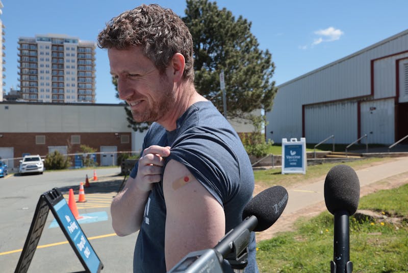 Nova Scotia Premier Iain Rankin proudly shows off his bandage — with a smiley face — on his arm after getting his first shot of the COVID-19 vaccine at a clinic at the Halifax Forum Multi-Purpose Centre Monday. - Eric Wynne