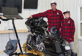 Jeff MacKinley, left, and his son Corbin showcase their high-end motorcycle tuning meter at MacKinley Motorsports in Cornwall.