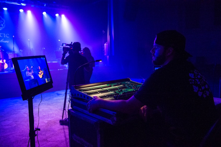 Brett Sutherland, right, from Sound Source Pro Audio adjusts the sound while Howie MacDonald and Mary Beth Carty can be seen performing on stage at Membertou Trade and Convention Centre during Celtic Colours at Home 2020. CONTRIBUTED • COREY KATZ