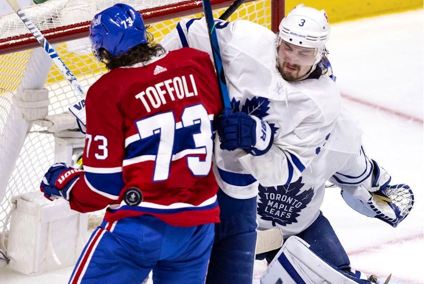 Montreal Canadiens right-wing Tyler Toffoli takes a puck in the back as Toronto Maple Leafs defenceman Justin Holl tries to clear him from the crease in Montreal on May 25, 2021. 