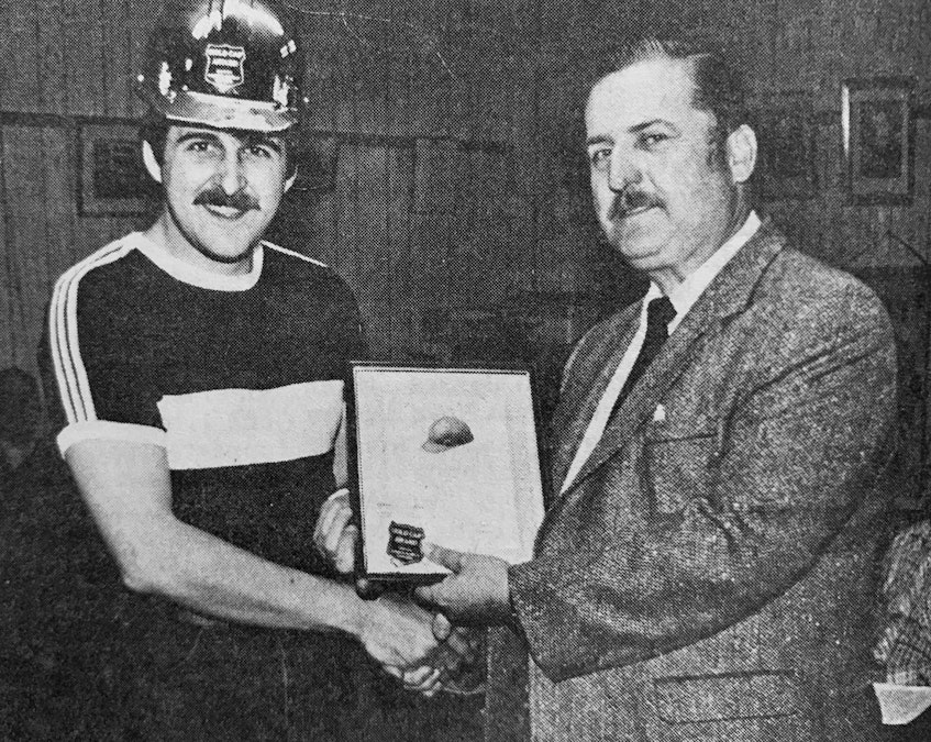 In 1986, Windsor firefighter John Sweet received the Gold Hat Award from Russ Mackintosh, the accident prevention officer with the provincial Department of Labour’s occupational health and safety department. Wearing a helmet saved Sweet from serious injury when falling bricks from a chimney fire fell around him. - File Photo