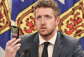 May 3, 2021 - Nova Scotia Premier Iain Rankin holds up a cellphone while asking young people to research the effects of the variants of COVID-19 during an online update on the state of the pandemic in the province on Monday, May 3, 2021.