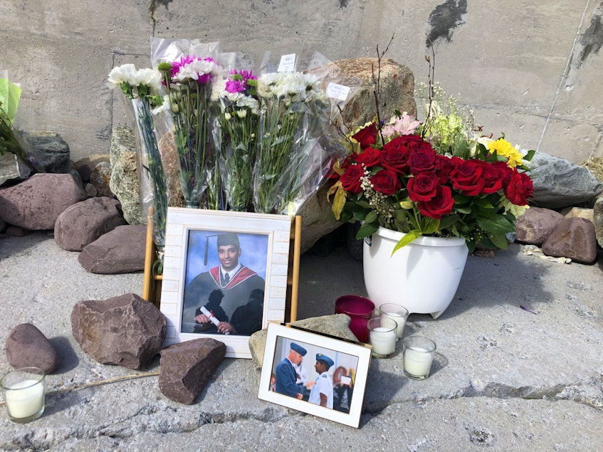 Candles, flowers and photos are arranged among rocks in a makeshift memorial to Supul Jayasinghe. — Joe Gibbons/The Telegram