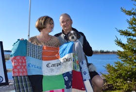 Williams and and her partner Bob Terweeme show off a quilt made from Kylar's old clothes.