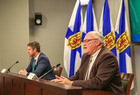 Nova Scotia Premier Iain Rankin listens as Dr. Robert Strang, the province's chief medical officer of health, speaks at a COVID-19 briefing in Halifax on Friday, May 28, 2021.