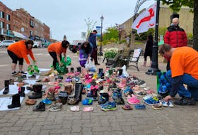 Demonstrators begin removing shoes to be taken for a ceremony at Abegweit First Nation. 